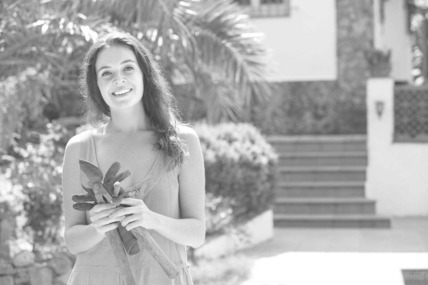 Çiçek düzenleme atölyesinde renkli çiçeklerle çalışan eğitmen, masa üzerinde farklı çiçek türleri ve düzenleme araçları